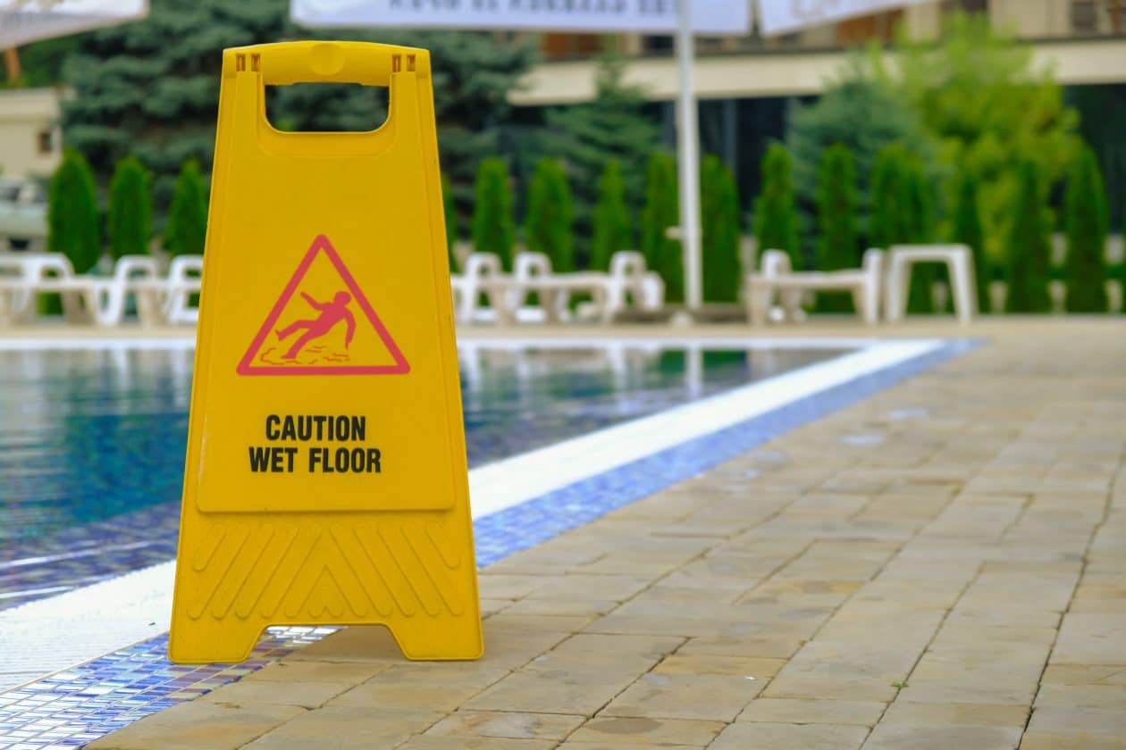 Advertencia de piso mojado cerca de la piscina en el hotel.